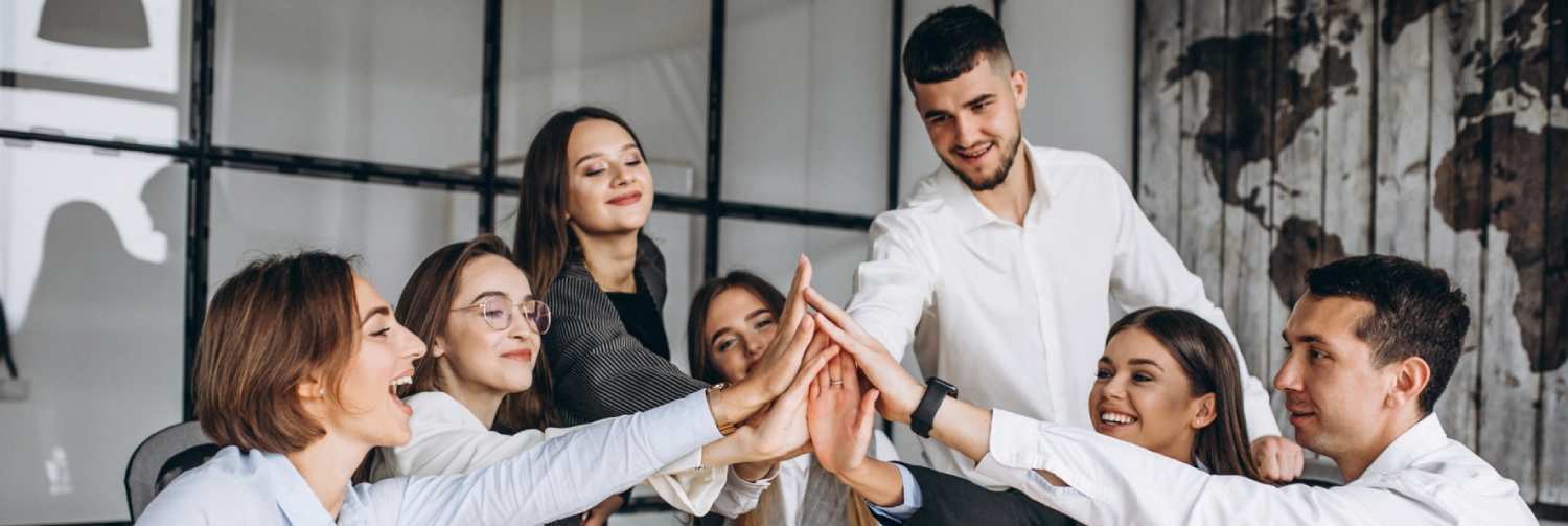 Team von Mitarbeitenden beim gemeinsamen High-Five im Büro